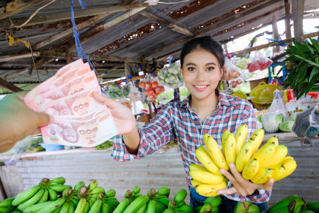 La mujer comerciante vende verduras, frutas y plátanos que están ...